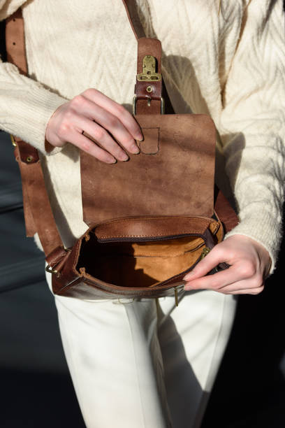 istock beautiful woman posing with a empty small brown bag near grey wall 2150786506