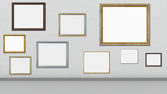 Frames, empty paintings on display on white wall. Nine frames with empty space for inserting text or images. Wooden, silver and gold frames.