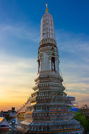 Small Prang, the side tower of the Wat Arun (Temple of Dawn) at Bangkok, Thailand. Wind god Vayu on horseback against dusk sky. Encrusted with coloured faience