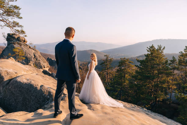 istock beautiful young bride and groom standing among the rocks. 2150788932