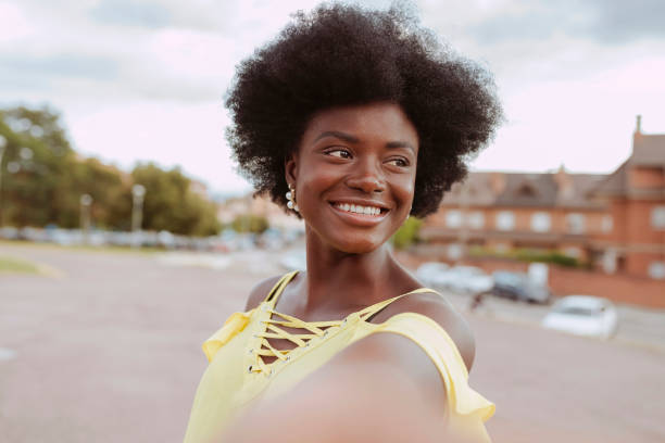 istock Young smiling afro woman taking selfie at park 2150790063