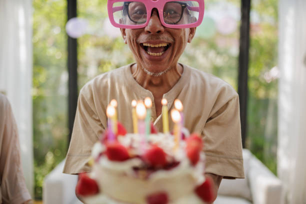 istock Funny senior man with a birthday cake 2150791056
