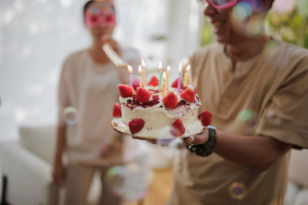 Smiling senior man holding a birthday cake.