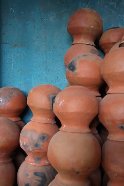 istock pots are gathered and arranged in a pattern in the empty space. The potter works on a pottery wheel to made of soft colored clay, retro style toned Clay pots with hand and equipment 2150791282
