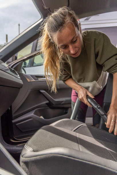 istock Woman Diligently Vacuuming Car Interior 2150792640