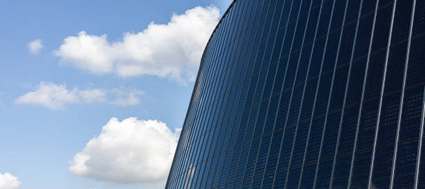 istock Panoramic view of modern office building against blue sky with clouds 2150793424