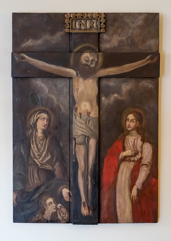 Antique carved wooden painting with a relief cross representing the crucifixion of Jesus Christ flanked by holy women. Corpus Christi Convent, Vila Nova de Gaia, Portugal. 2023-01-13
