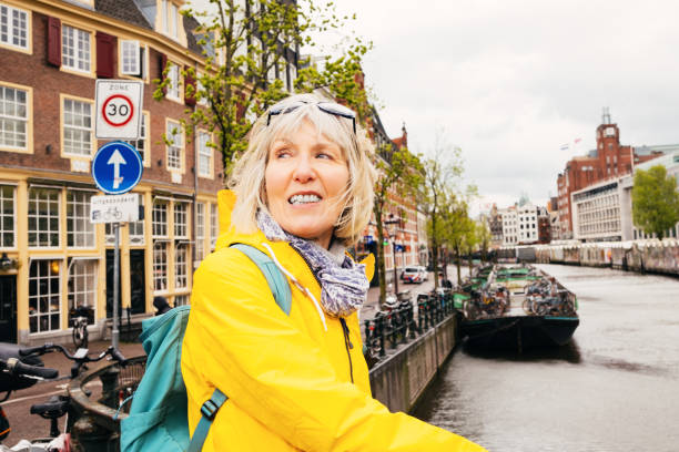Senior woman making the most of a grey day visiting Amsterdam in the Springtime.