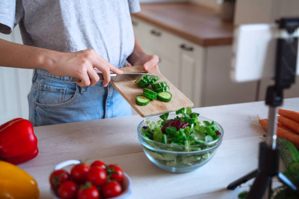 istock Beautiful Girl Preparing Fresh Salad in a Bright Kitchen. 2150801000