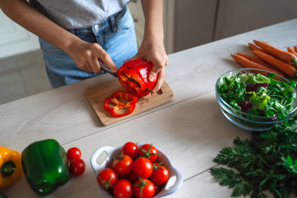 istock Beautiful Girl Preparing Fresh Salad in a Bright Kitchen. 2150801007