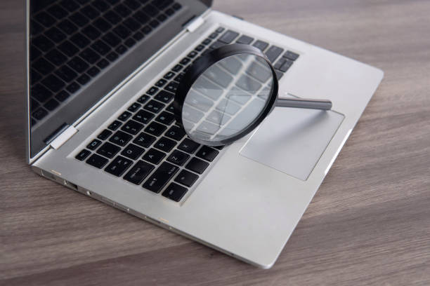istock Closeup image of magnifying glass and laptop. 2150801206