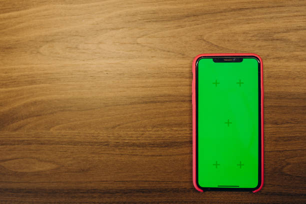 istock The smartphone has a green screen on an old wooden floor. 2150801539