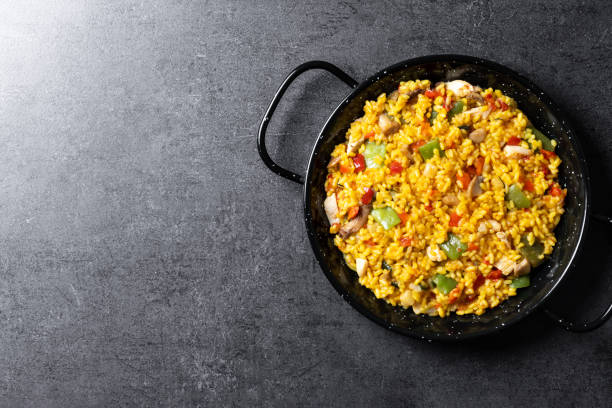 istock Yellow rice with chicken and vegetables on black slate background 2150801735