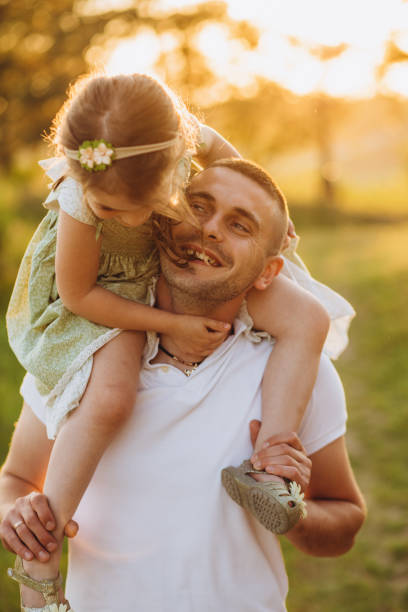 istock Happy father playing and carrying his daughter on shoulders. 2150801919