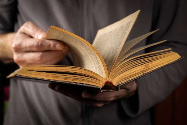 istock Men opening and reading a old book, close up 2150802779