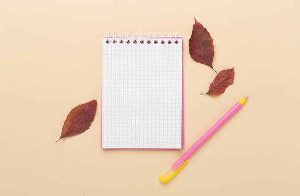istock Autumn leaves with notebook on color background, top view 2150803439
