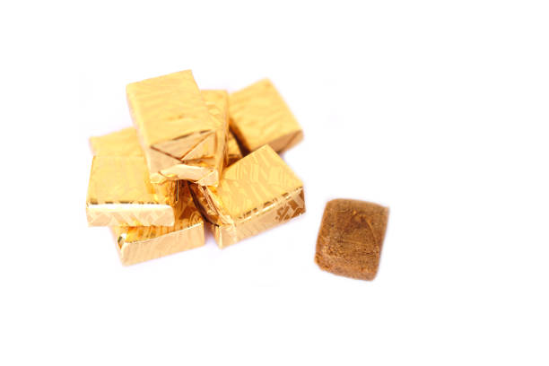 Bouillon cubes, stock cube or soup cubes, wrapped with golden paper isolated on white background. Concept, food flavoring for making delicious soup or curry.