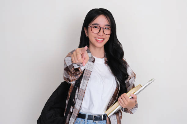 istock Female college student smiling and pointing at the camera 2150805450