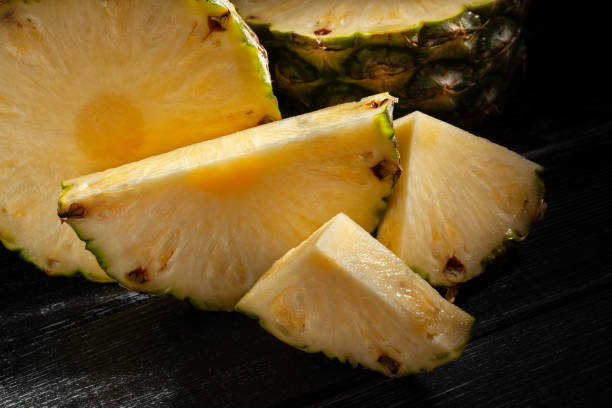 istock sliced pineapple on black wood 2150805814