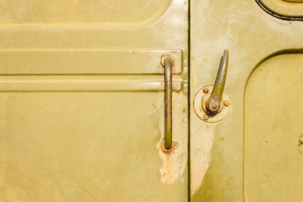 Handle for military vehicle door. Design elements and details of the old Soviet military equipment. Military green camouflage metal background. Closeup