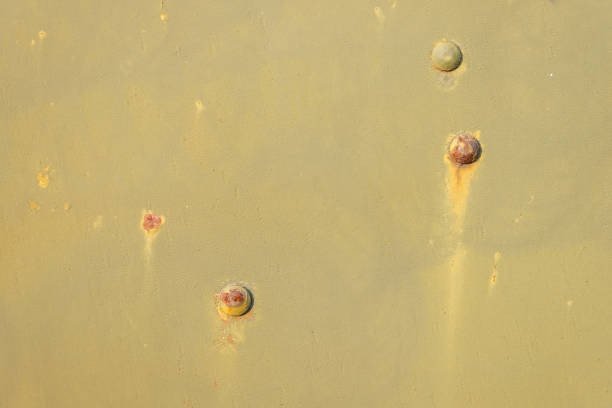 Detail of an old camouflage surface with exfoliated paint  and rivets on military equipment. Military background