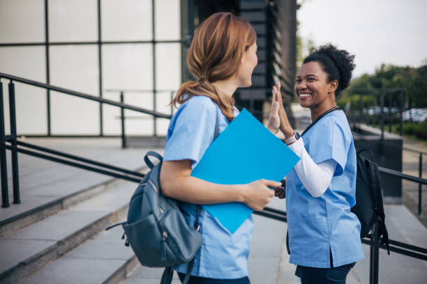 A picture of two women, health workers at the hospital, high-fiving each other.