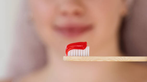 istock Close-up of red toothpaste on bamboo brush. 2150807042