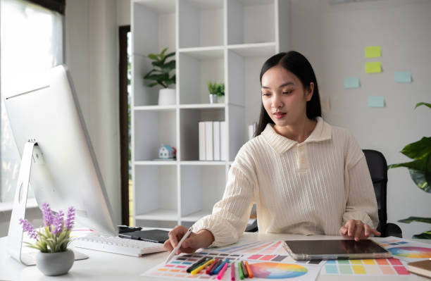 istock Female designer working in graphic design on computer Sit and choose colors and work intently in your office. 2150807143