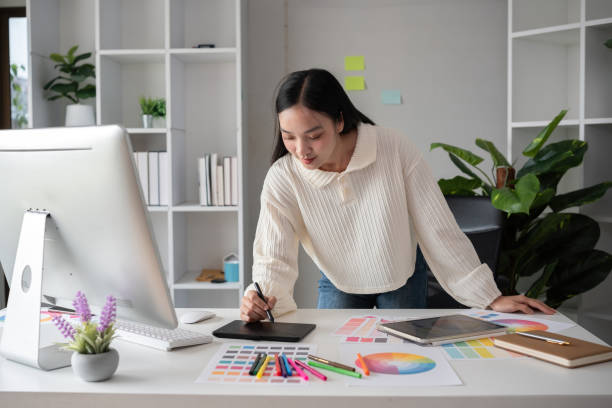 Female designer working in graphic design on computer Sit and choose colors and work intently in your office.
