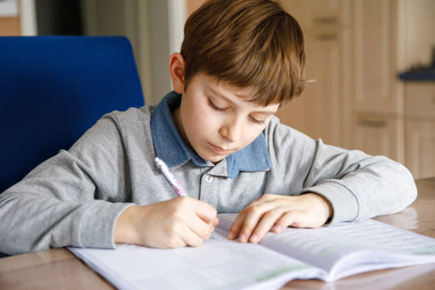 istock Upset school kid boy making homework during quarantine time from corona pandemic disease. Crying and sad boy frustrating staying at home. 2150808899