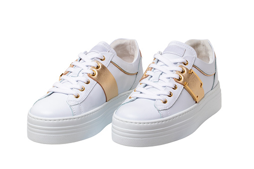 White sneaker isolated. Close-up of a pair white elegant stylish female leather high-heeled sport shoes isolated. Clipping path. Womens shoe fashion. Modern design footwear for workout.