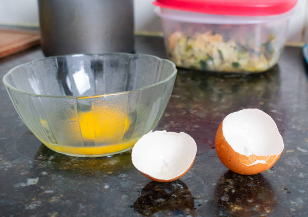 eggshells and yolks placed inside a bowl, highlighting their organic quality and suitability for culinary use, indicating their freshness and natural appeal for cooking purposes.