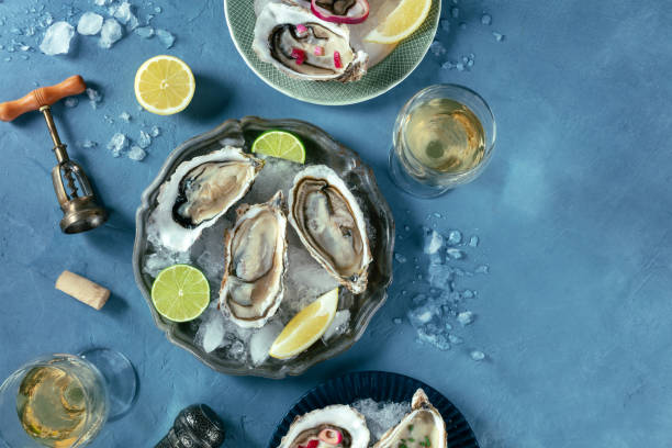 istock Oysters on ice, with various toppings and white wine, overhead flat lay shot 2150810613