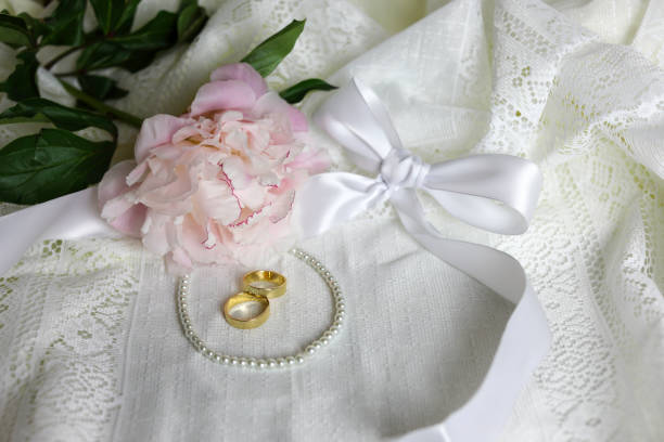 Pink peony flower, white silk bow and pearls.