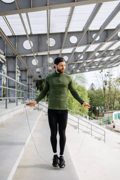 istock Urban Stadium Workout: Athletic Man Confidently Jumps Rope in Concrete Environment 2150811747