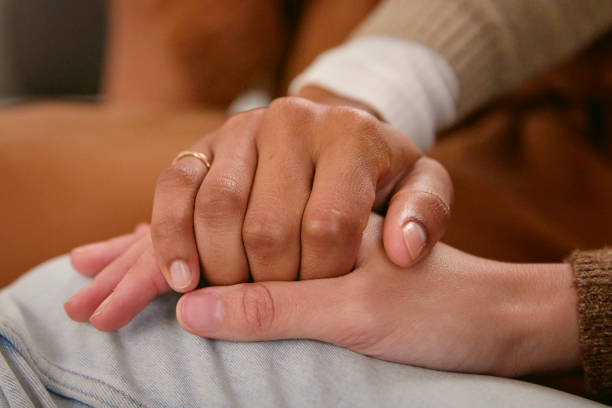 istock Shot of two friends holding hands supporting one another 2150816449