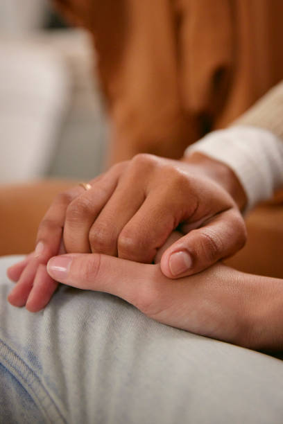 istock Shot of two friends holding hands supporting one another 2150816472