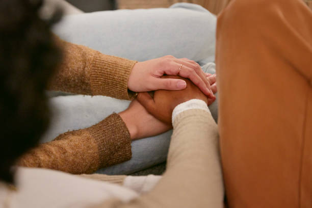 istock Shot of two friends holding hands supporting one another 2150816487