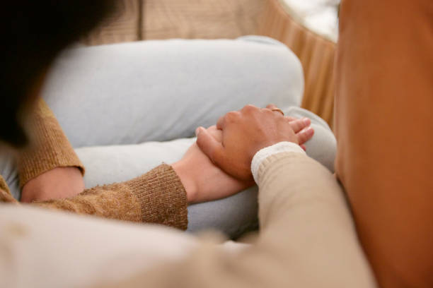istock Shot of two friends holding hands supporting one another 2150816490