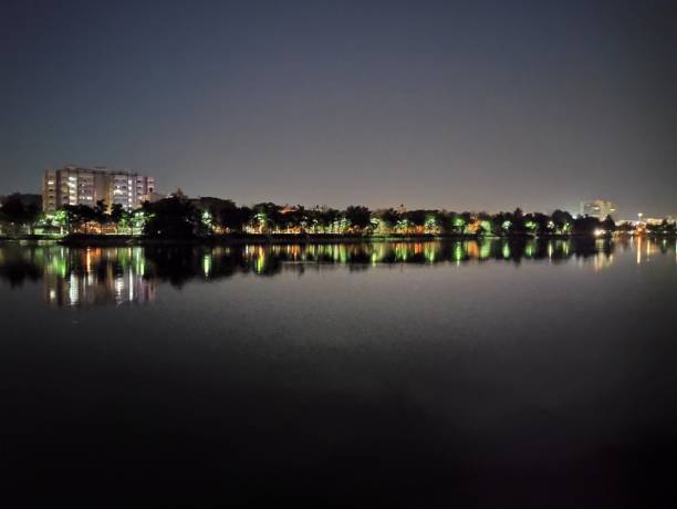 istock Tranquil night scene: calm water mirrors distant city lights beautifully. 2150816548
