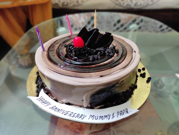 istock The image features a round, chocolate cake with a vanilla base, adorned with a single red candle and a chocolate decoration. 2150816636