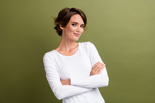 Portrait of attractive promoter lady holding arms folded experienced specialist isolated khaki green color background.