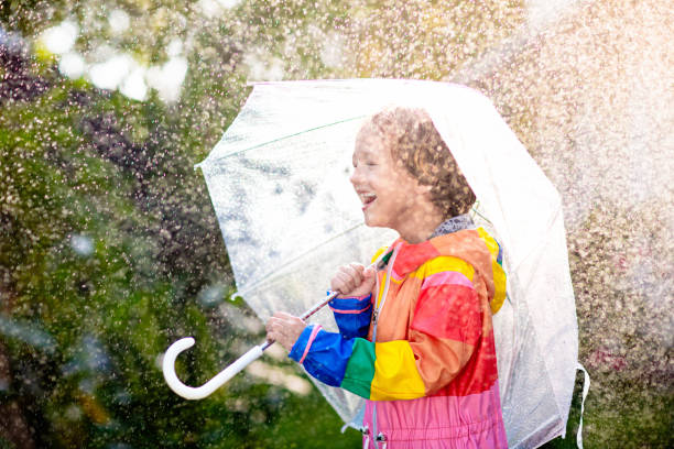 istock Child playing in autumn rain. Kid with umbrella. 2150821584