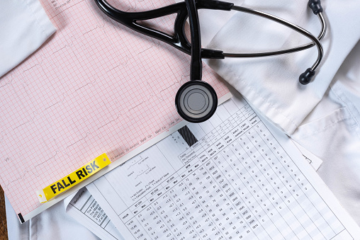 EKG, ECG, electrocardiogram, cardiac monitor report, lab coat, and stethoscope.  Heart health or disease concept.