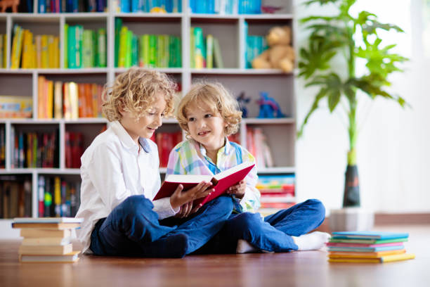 Child reading book. Kids read. Little boy at a colorful bookshelf doing homework for school. Student with books. Early education and development. Home library for children. Preschool kid study.
