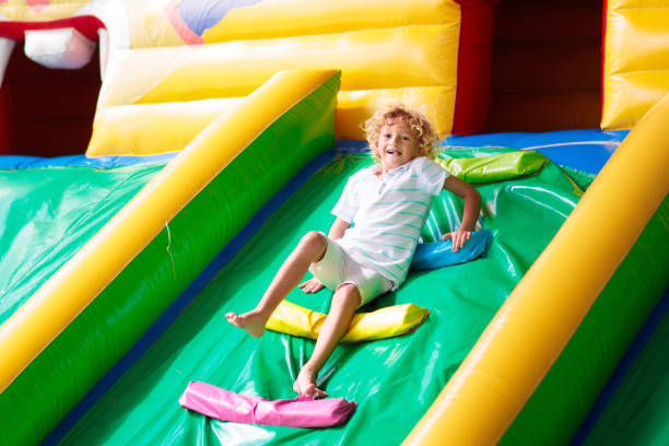 istock Child jumping on playground trampoline. Kids jump. 2150822548