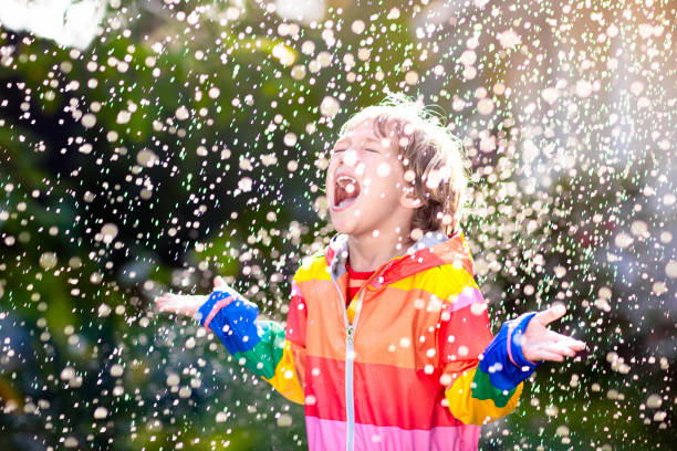 istock Child playing in autumn rain. Kid with umbrella. 2150823759
