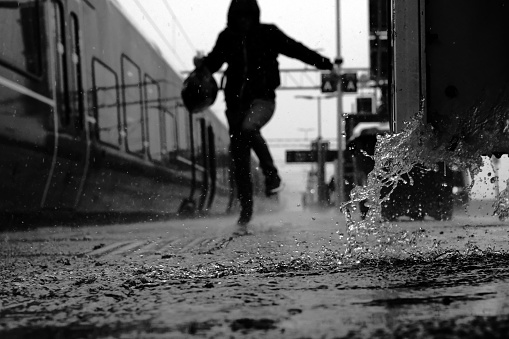 A man tries to escape the rain after getting off the train in Eidsvoll.