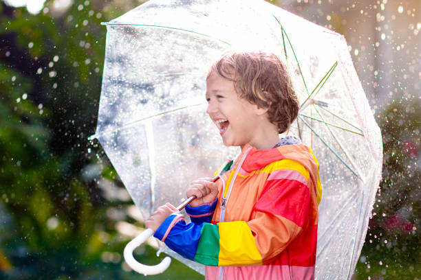 istock Child playing in autumn rain. Kid with umbrella. 2150825310