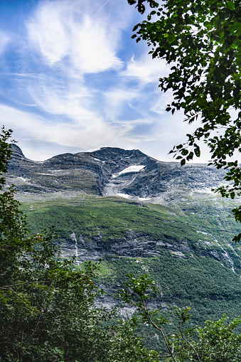 Looking up the towering peaks of Kaldfonna mountain, rugged rocky terrain with snow remnants in summer near Sunndalsøra, Norway